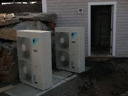 Daikin heat pump outdoor units beside a home