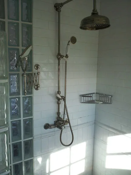Exposed-pipe rainshower fixture in a tiled shower